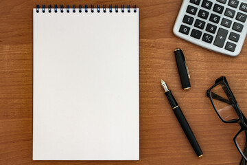 fountain pen with notepad on wooden table