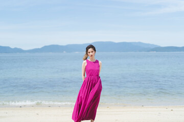 Fototapeta na wymiar リゾート地の海でワンピースを着た女性