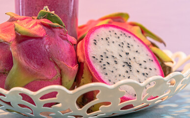 Pitaya juice and fruits (Hylocereus guatemalensis, H.undatus) in white tray on pink background