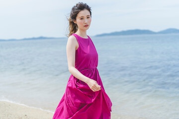 Fototapeta premium リゾートで海沿いを歩く女性