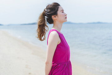 リゾートで海沿いを歩く女性