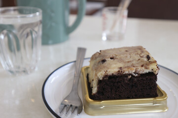 Chocolate brownies on a white plate in a coffee shop.