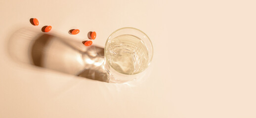 A glass of clean water with natural vitamins, with shadows on a light background. Flat lay