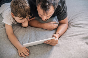 boy (6-7 years old) with his father watching cartoons on a tablet