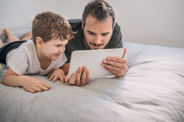 boy (6-7 years old) with his father using a tablet