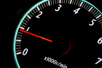 car tachometer with red arrow on black background