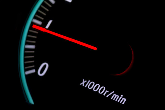 car tachometer with red arrow on black background