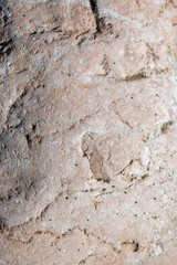 Naklejka premium Unregular textured cracked and scratched pink stone / rock wall background / texture / wallpaper / pattern