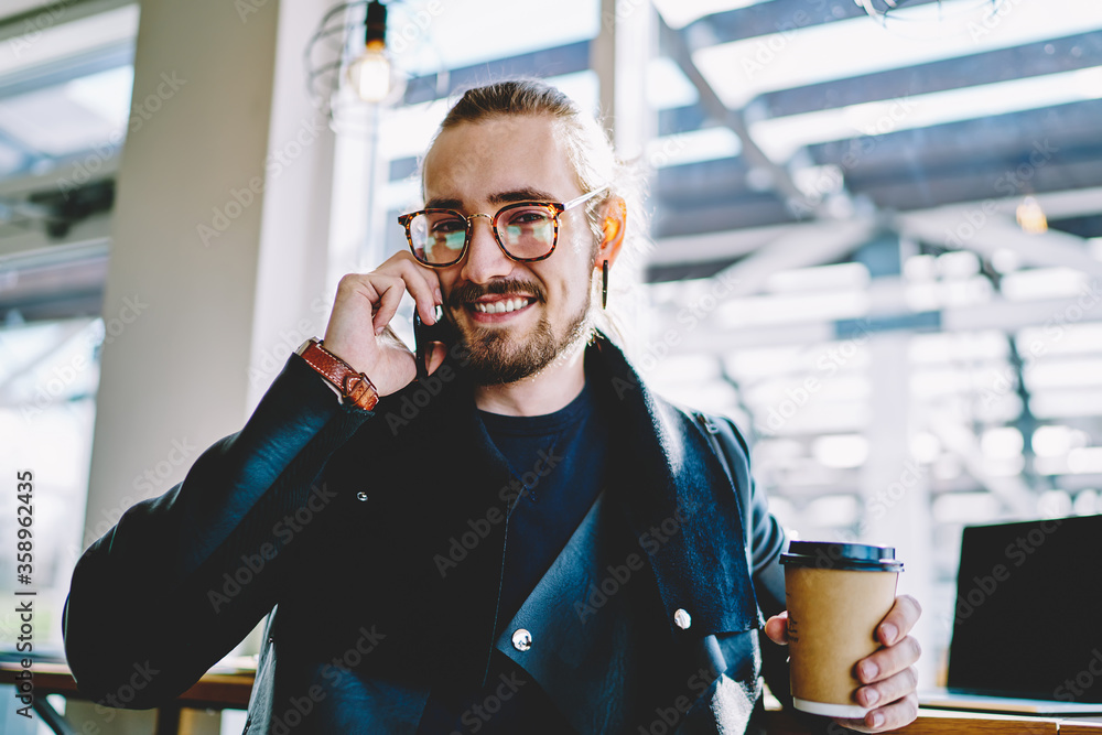 Poster close up portrait of joyful bearded hipster guy enjoying friendly conversation via cellular app duri