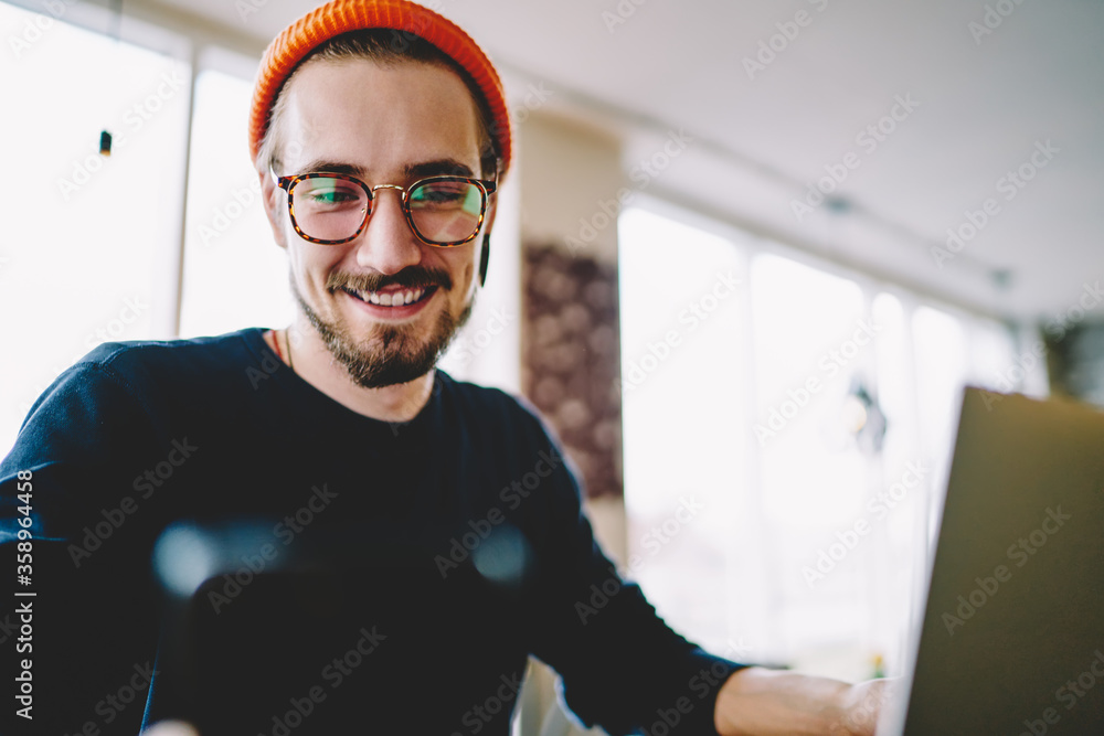 Poster happy caucasian freelancer reading positive web publication on cellphone technology smiling during w