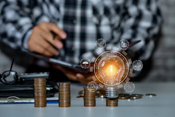 Business man holding light bulb on the Green background nature and writing on note book it for financial