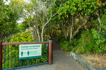 Obraz premium COVID19 Social Distancing notice on a national park walk.