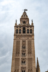 Fototapeta na wymiar It's Giralda, a former minaret that was converted to a bell tower for the Cathedral of Seville in Seville. UNESCO World Heritage