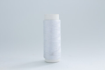 spool of white thread on a white background