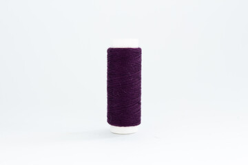 spool of purple thread on a white background