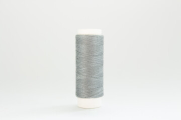 spool of gray thread on a white background