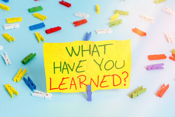 Handwriting text writing What Have You Learned Question. Conceptual photo to know the things acquire or absorb Colored clothespin papers empty reminder blue floor background office pin