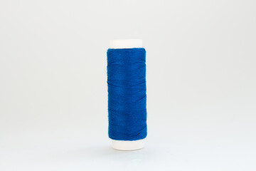 spool of blue thread on a white background