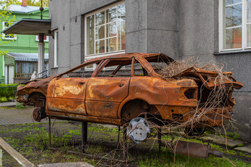 Parnu (Pärnu)/ Estonia - May 14 2020: Abandoned Audi wreck rusting in the city street. Wrecked Audi, smashed and burned automobile.