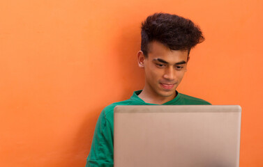 A Young Man teasing someone and showing tongue on a video call on his laptop.