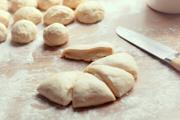 Fresh yeast dough for pizza or bread, cut into small pieces and rolled into the balls on floured table