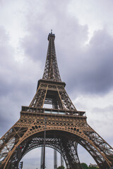 Obraz premium The eiffel tower on a cloudy day, in Paris, France, a low angle shot.