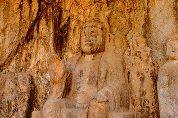 Fototapeta na wymiar It's Buddha statue at the Longmen Grottoes ( Dragon's Gate Grottoes) or Longmen Caves.UNESCO World Heritage of tens of thousands of statues of Buddha and his disciples