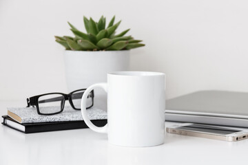 White mug mockup, modern workspace with laptop, notebooks and plant