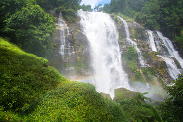 Closed up water fall located in deep rain forest jungle with rainbow named 