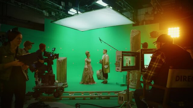 On Big Film Studio Professional Crew Shooting History Costume Drama Movie. On Set: Director Controls Cameraman Shooting Green Screen Scene with Two Actors Talented Wearing Renaissance Clothes Talking