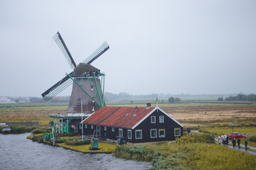 Windmills in Zaanse Schans village, near the sea coast, on a cloudy day.