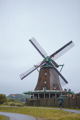 Fototapeta na wymiar Windmills in Zaanse Schans village, near the sea coast, on a cloudy day.
