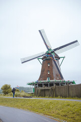 Windmills in Zaanse Schans village, near the sea coast, on a cloudy day.