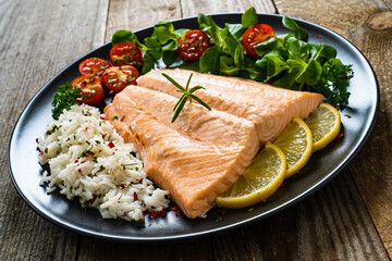 Steamed salmon fillet with basmati rice vegetables on wooden table