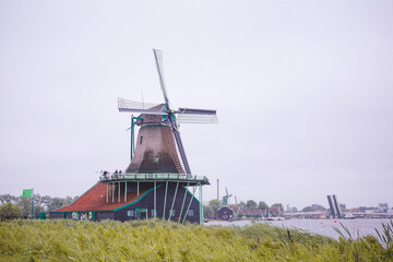 Windmills in Zaanse Schans village, near the sea coast, on a cloudy day.