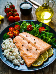 Steamed salmon fillet with basmati rice vegetables on wooden table