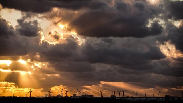 Day to night timelapse of an industrial electric windmill sunset landscape