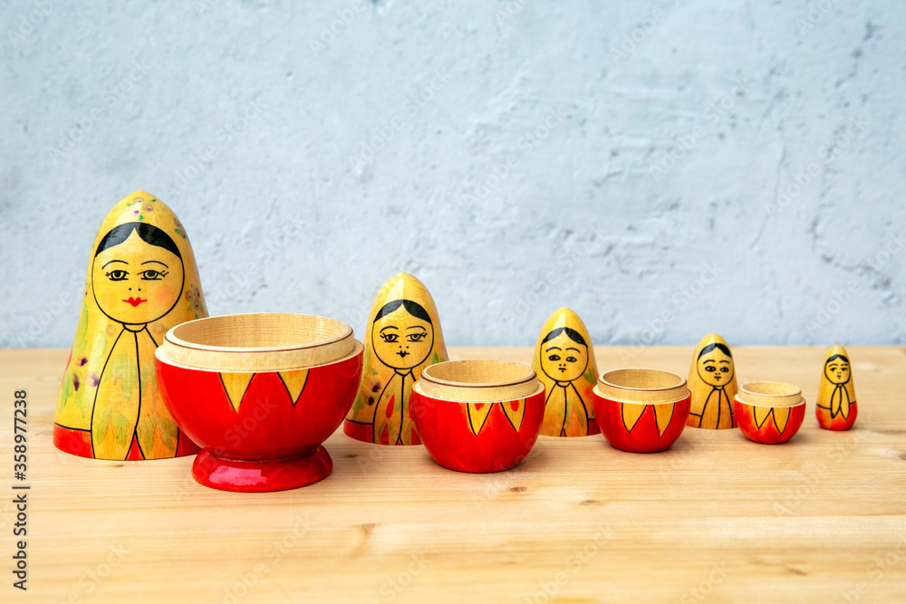 Wall mural russian dolls on wooden table with grey background