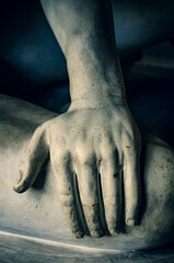 Graceful hand of male antique sculpture laid on the leg - closeup of vintage plaster cast
