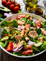 Salmon salad - roasted salmon and vegetables on wooden background
