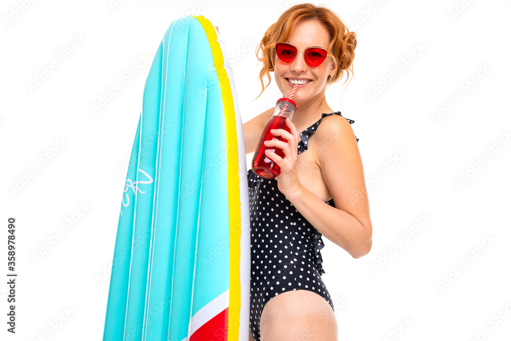 Wall mural sexy girl with inflatable swimming circles and mattresses on vacation on a white background