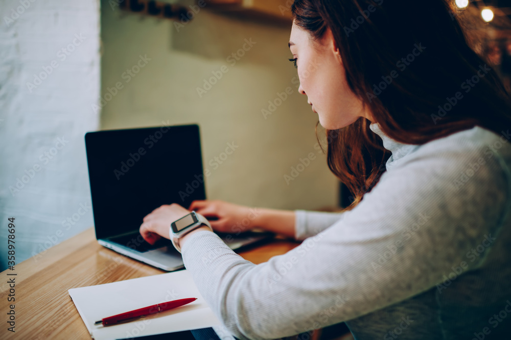 Poster professional female freelancer typing on laptop computer working distantly on development in coworki