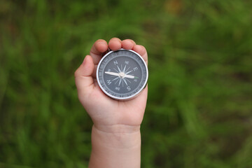 Old classic navigation compass in hand on natural background