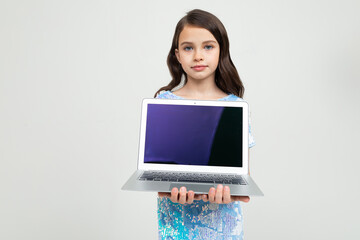 teen girl holding a laptop with a blank screen to insert a website on a white studio background