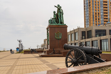 Novorossiysk, Russia - March 25, 2020. - Monument to fathers of founders of city on the embankment. Composition represents granite pedestal with three figures. In background, building collapses.