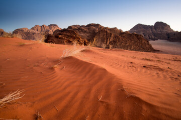 Fototapeta na wymiar Red sand dunes on Wadi Rum desert in Jordan. Spectacular landscape of orange desert.