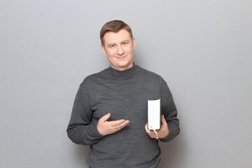 Portrait of happy man holding big book and pointing with hand at it