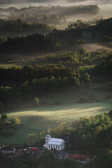 Aerial view of church surrounded by forest.