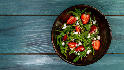 Spring salad with arugula, strawberries and ricotta. Food recipe background. space for text. top view.