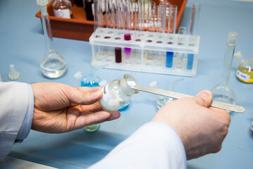 Male chemical doctor conducting chemical reaction with some white powder in laboratory